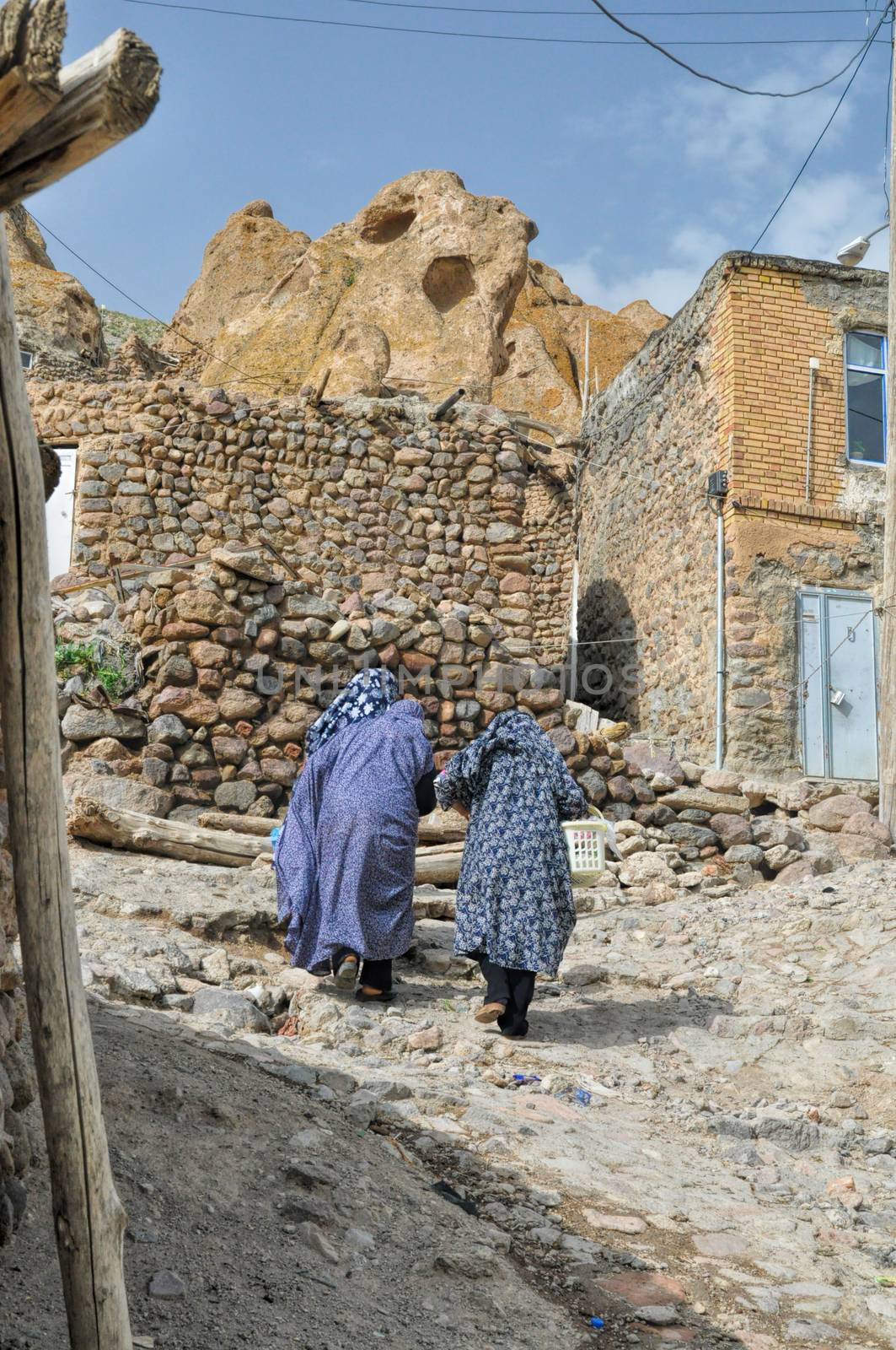 Two iranian women walking up the street in Kandovan village, northern Iran