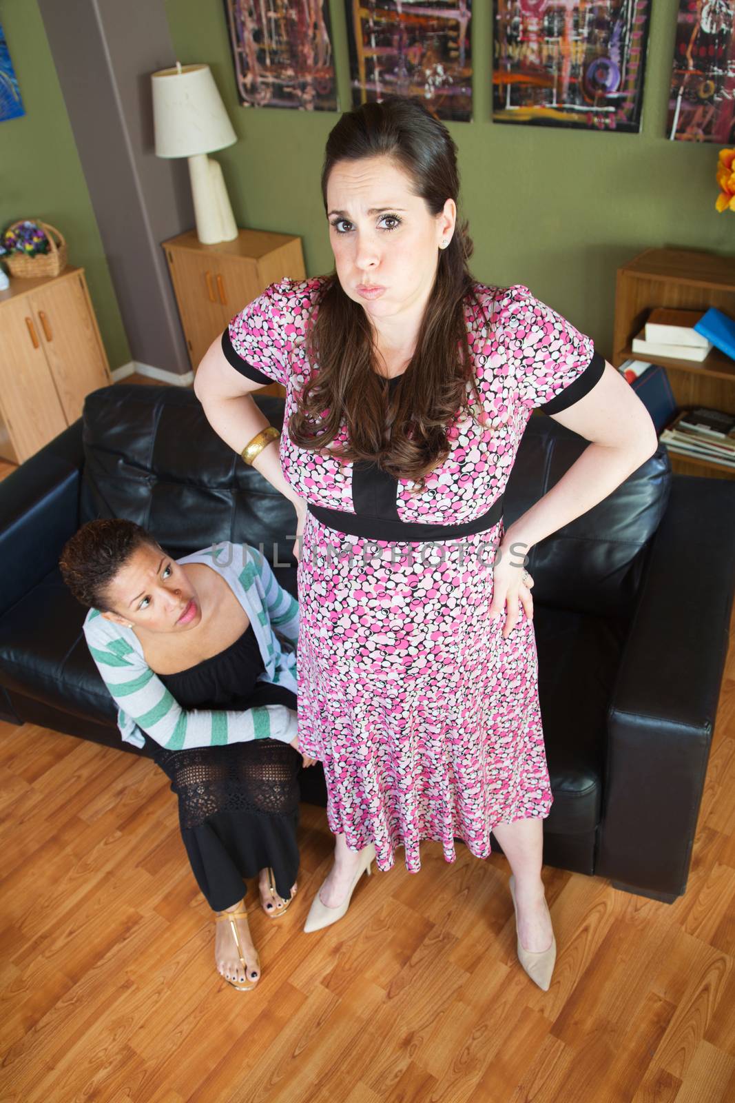 Female spouse with fatigued pregnant woman with hands on hips