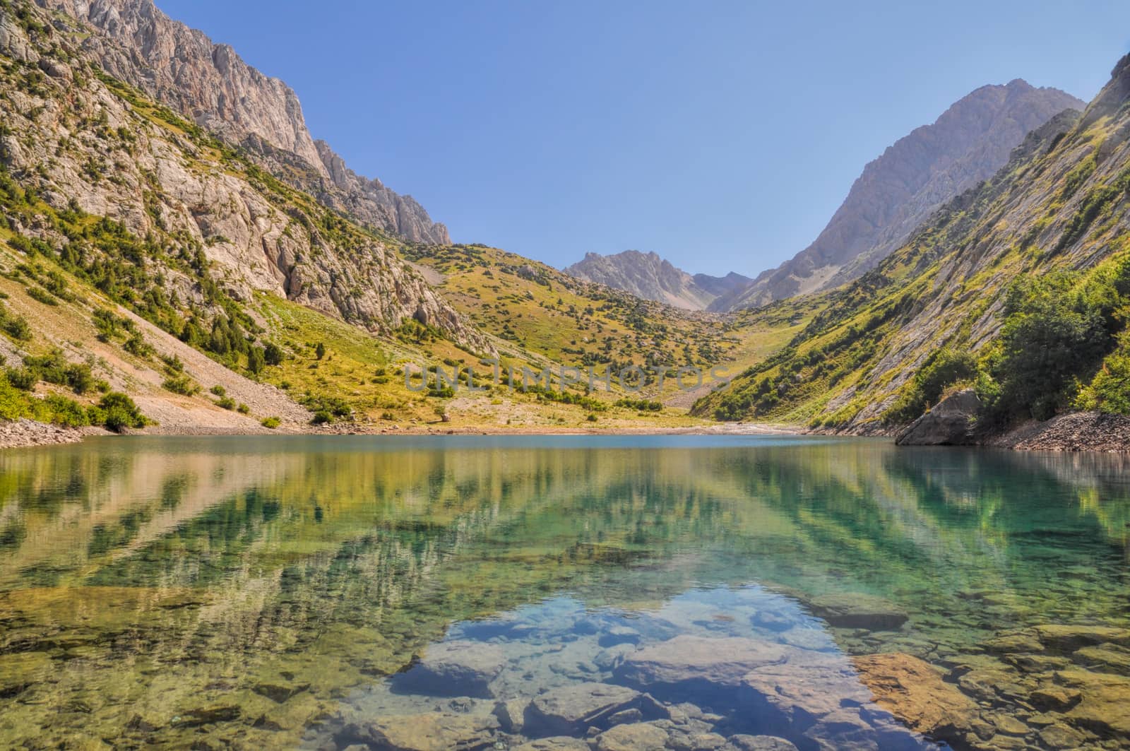 Crystal clear lake in mountain range Tien-Shan in Kyrgyzstan