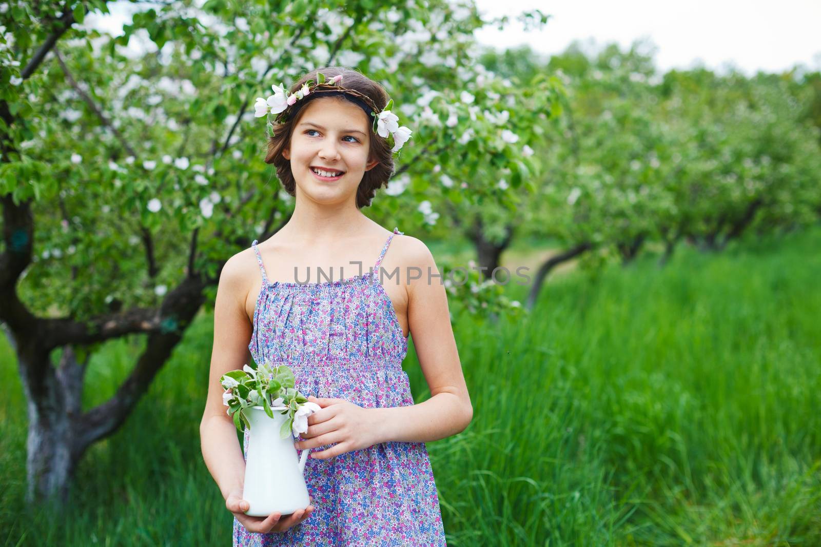 Adorable girl in blooming apple tree garden on spring day