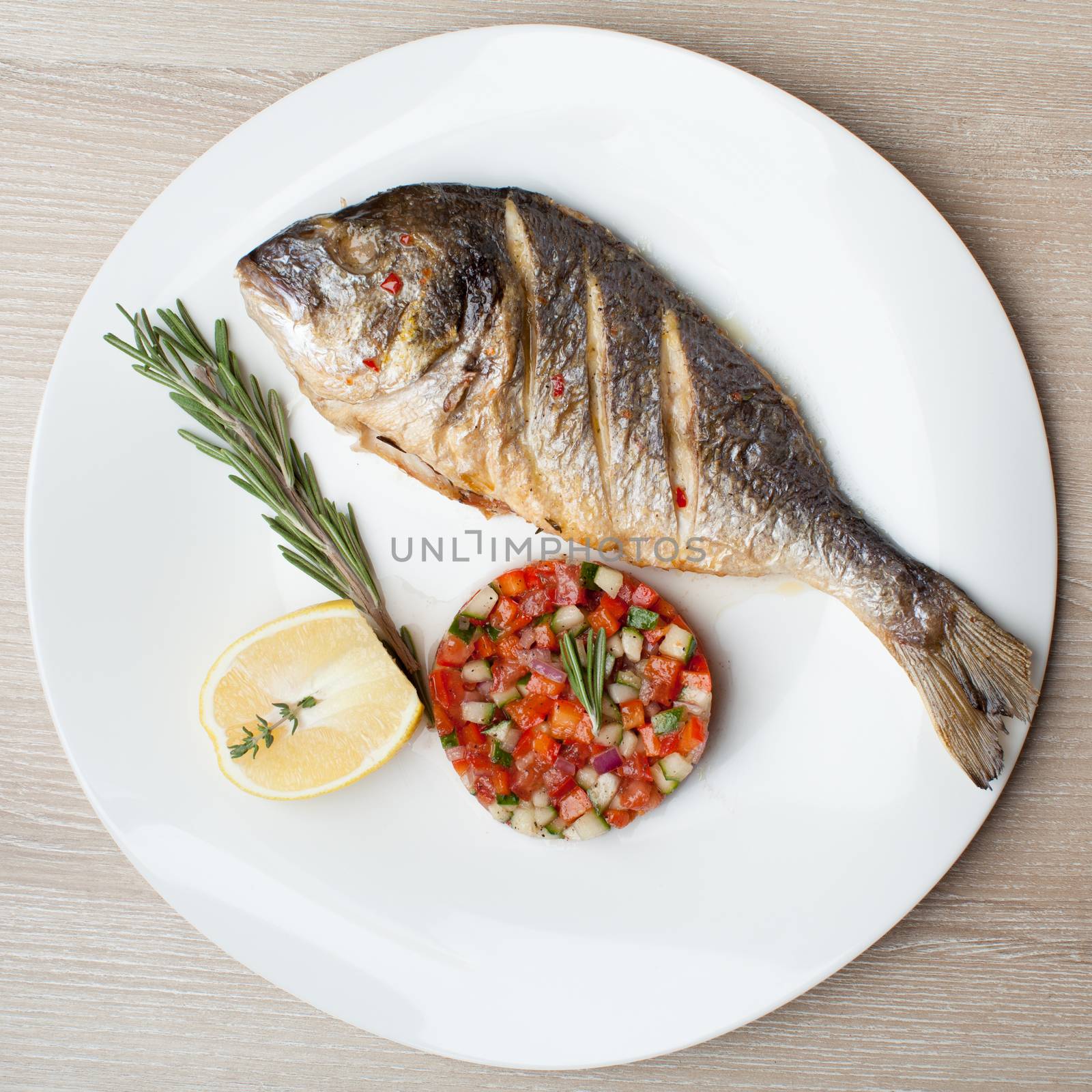 Gourmet Mediterranean seafood dish. Grilled fish gilthead with v by SergeyAK