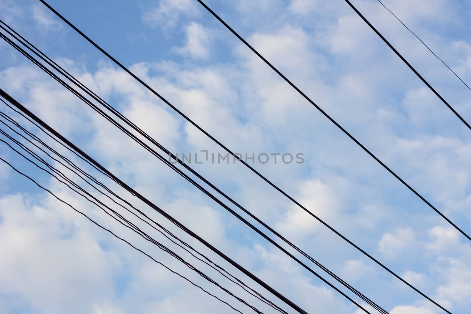 electric wires, blue cloudy sky in the background.