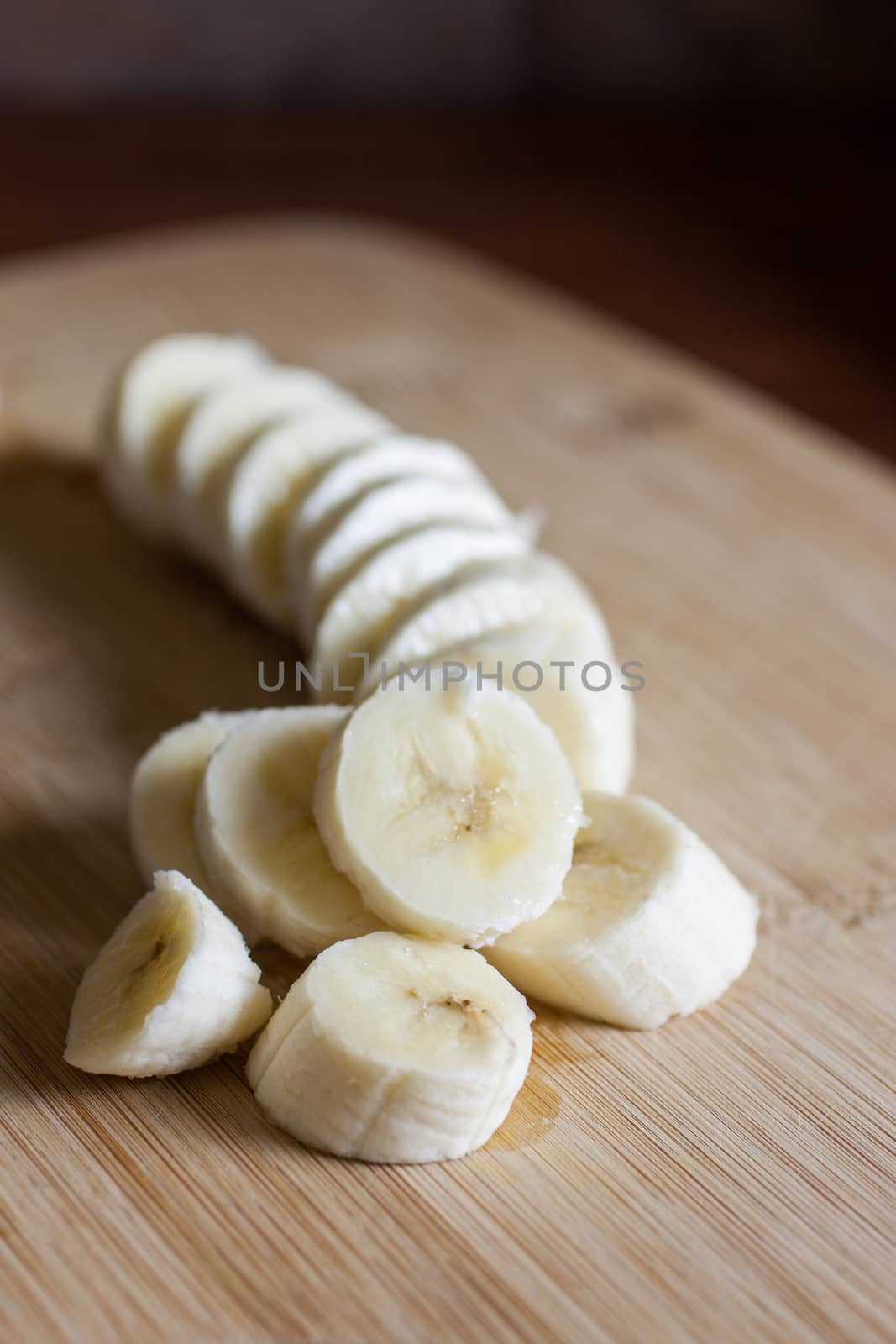 A cut banana on a bamboo cutting board in the morning sunlight.