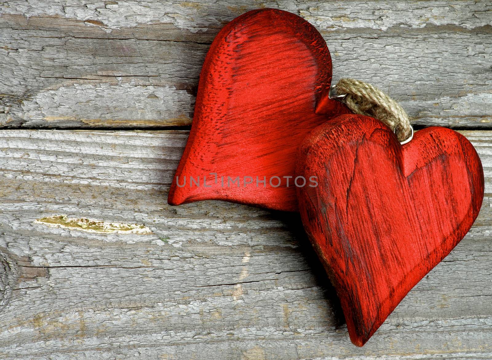 Pair of Handmade Wooden Red Hearts isolated on Rustic Wooden background. Top View