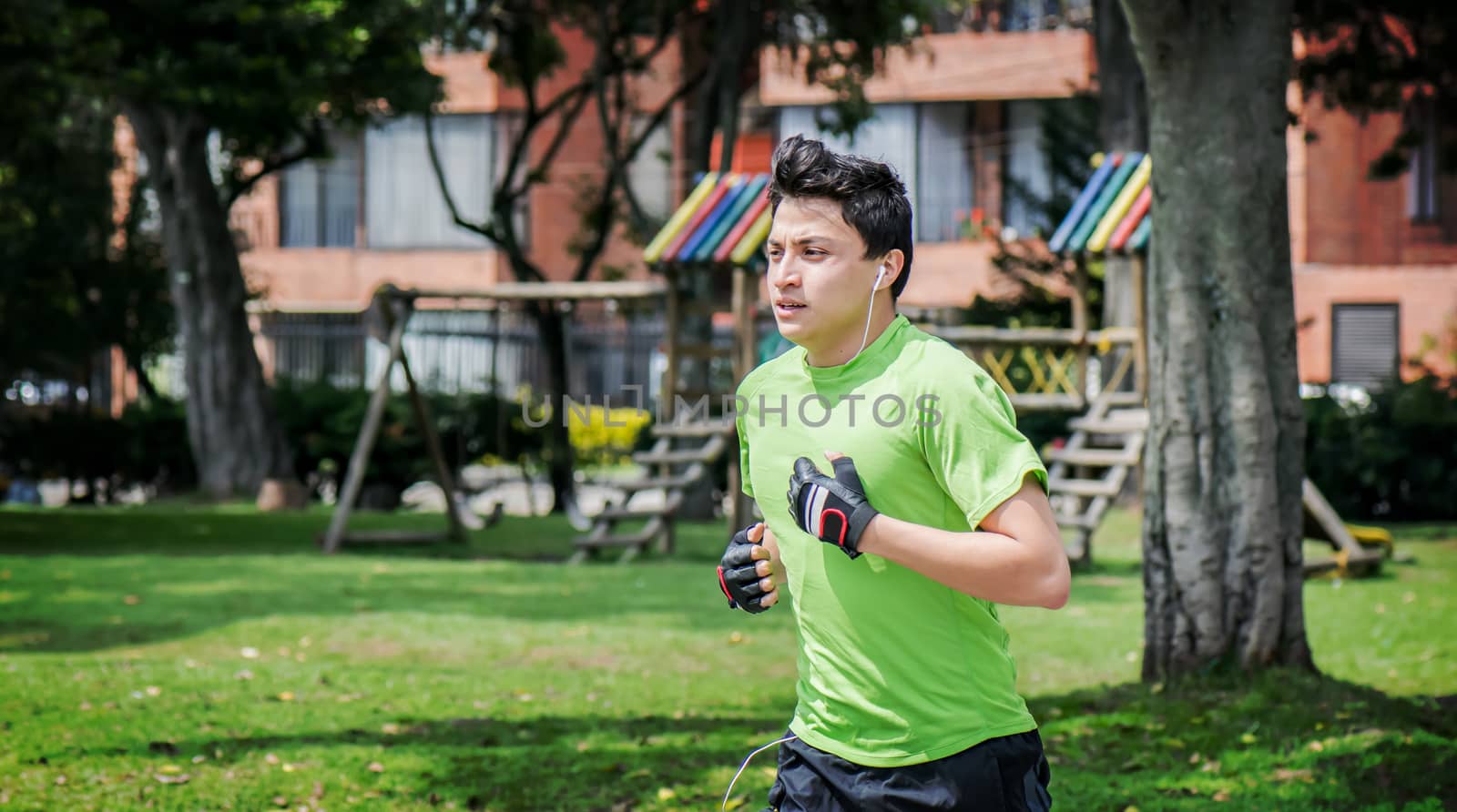 Young man at a local park jogging near home 