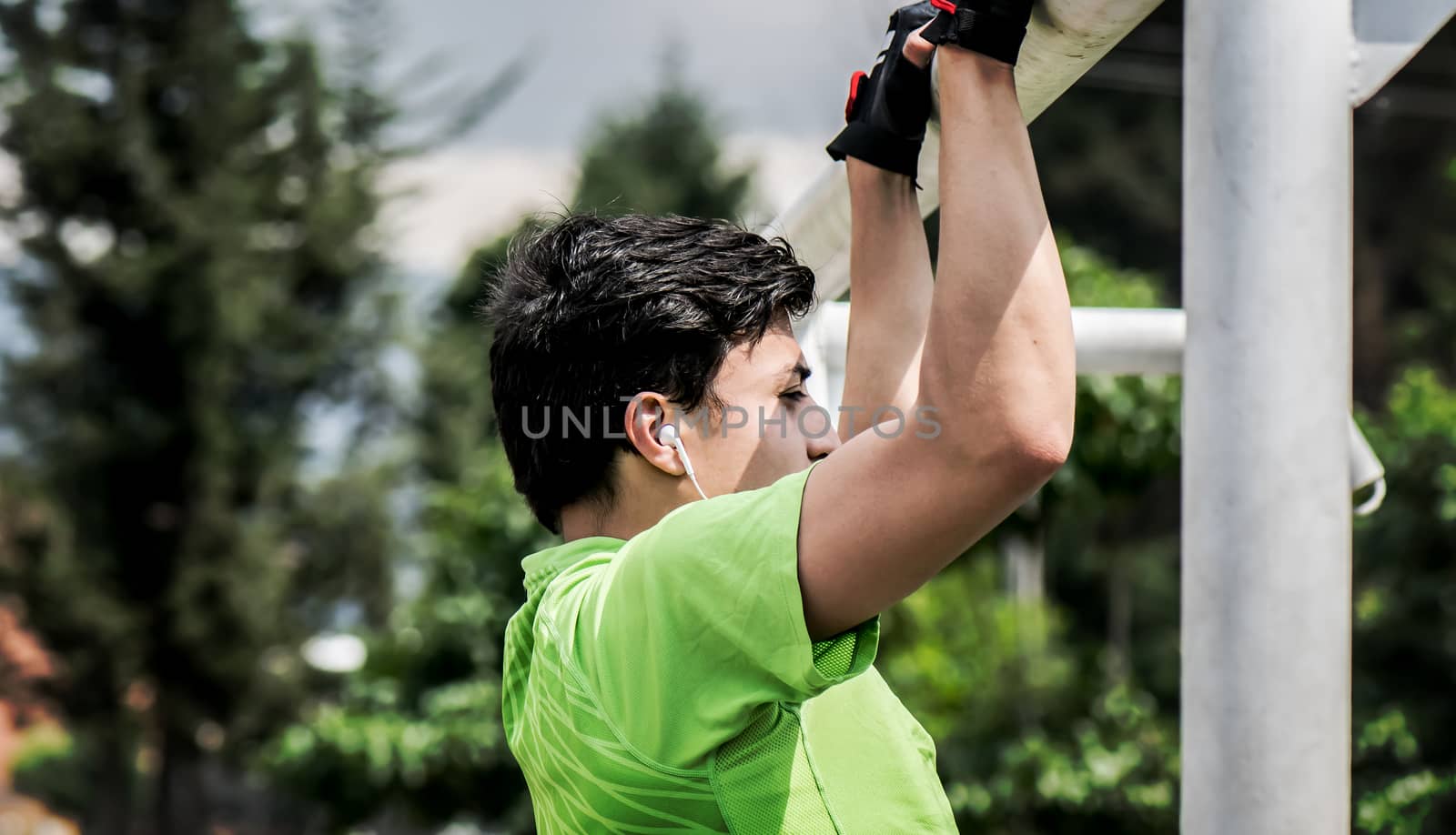 Young man doing pull-up on horizontal bar