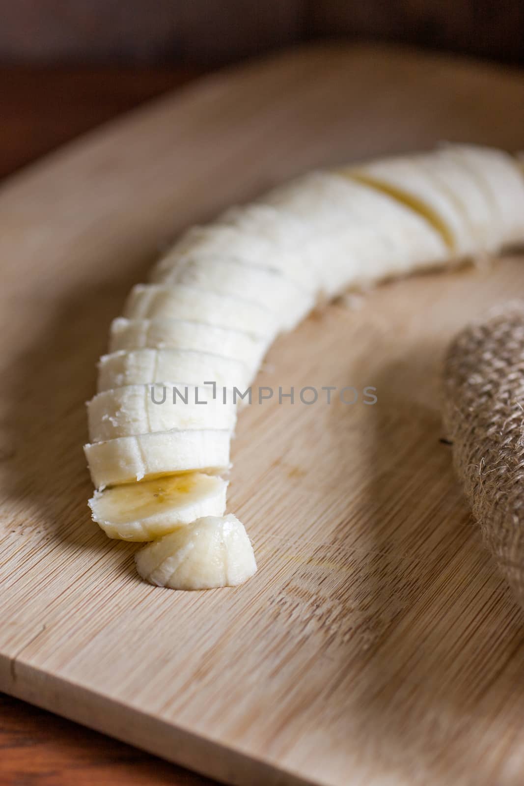 A cut banana on a bamboo cutting board in the morning sunlight.