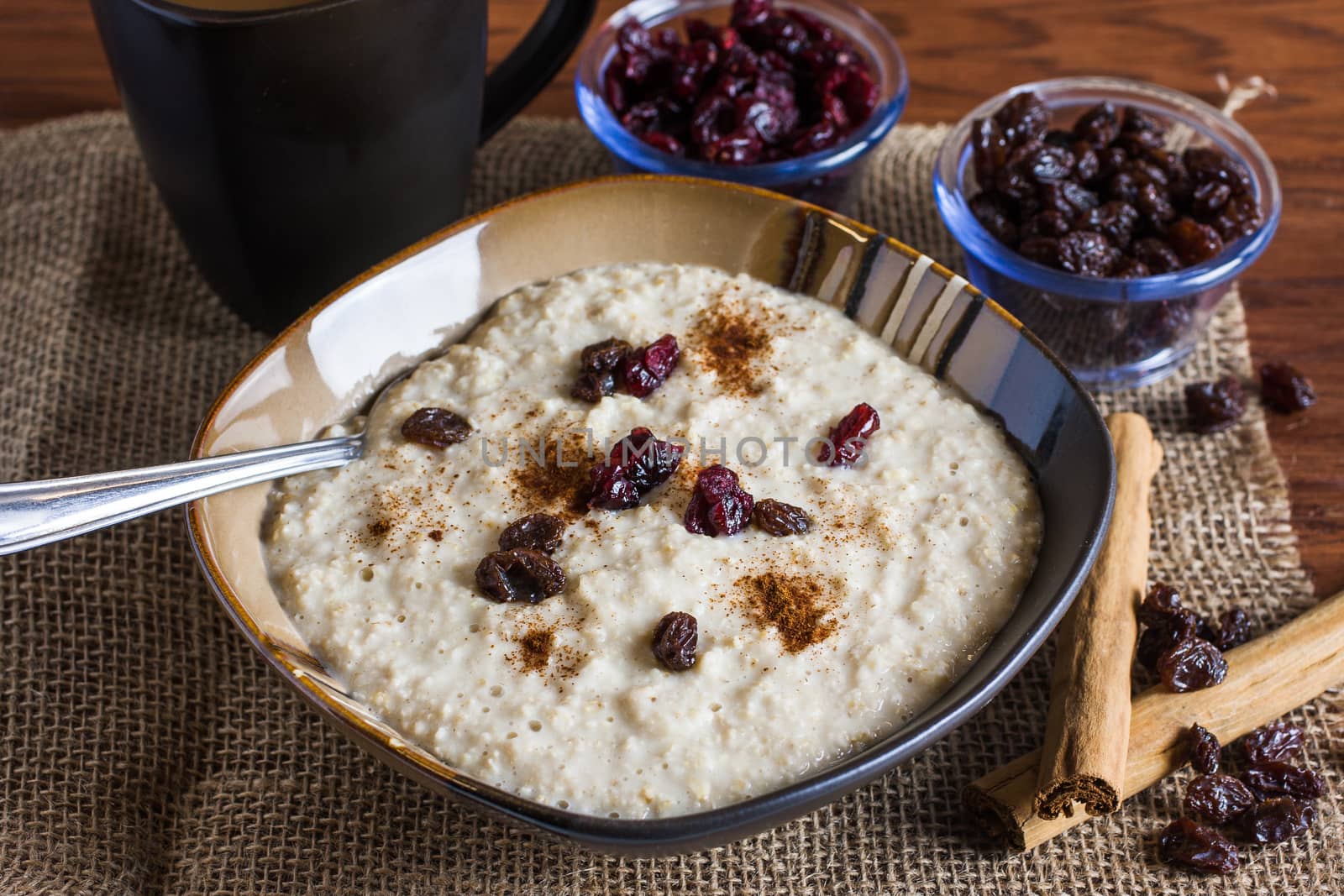 An early morning breakfast of fruit and oats with coffee with morning light reflecting in from the right.