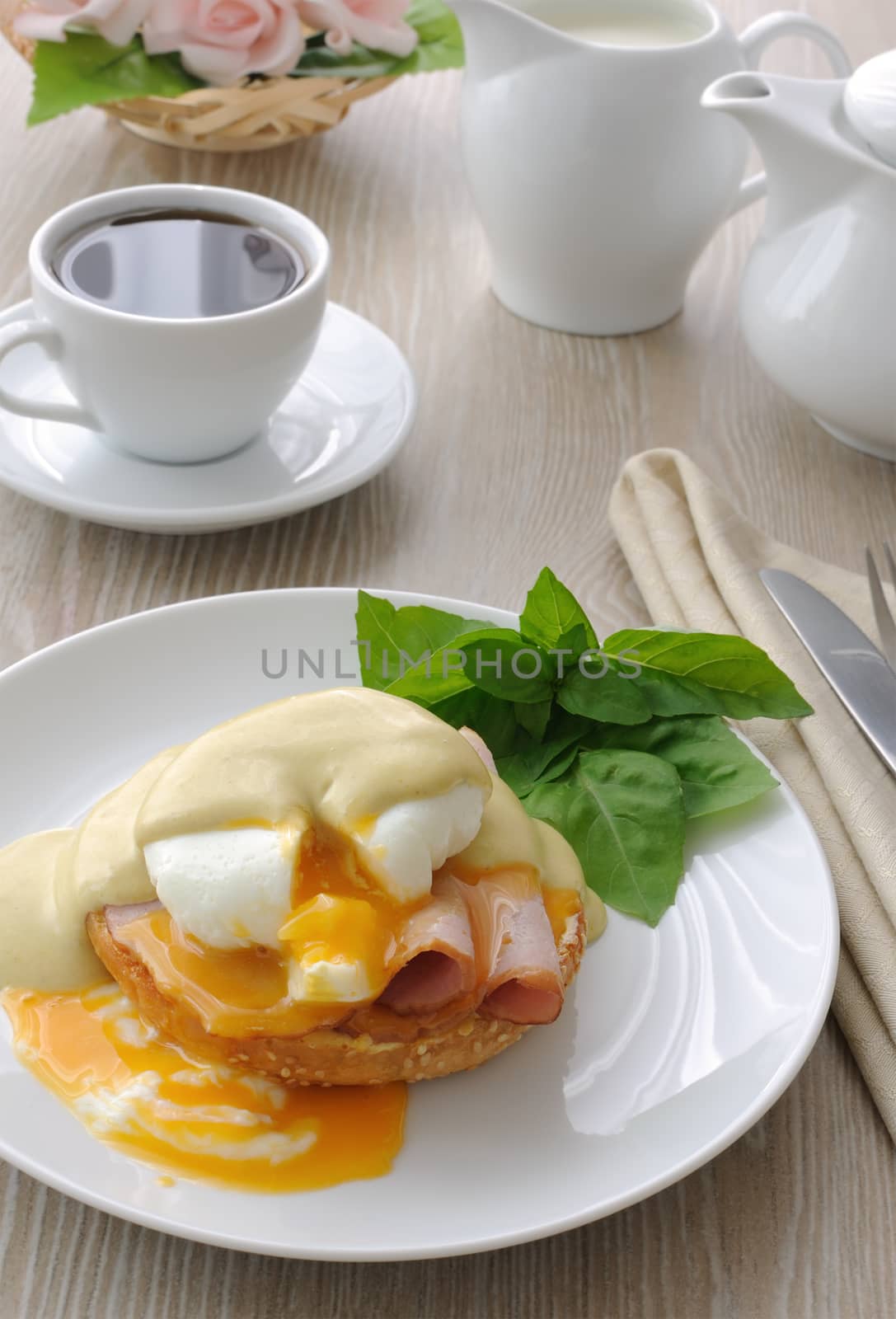 Breakfast of boiled eggs (poached) with ham on a bun with mustard sauce