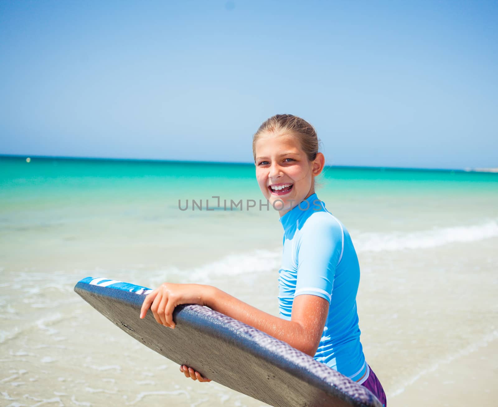 Teenage girl in blue has fun surfing