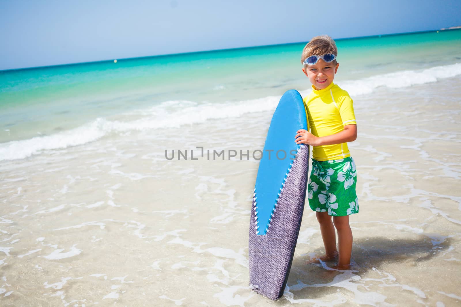 Little boy in yellow has fun surfing