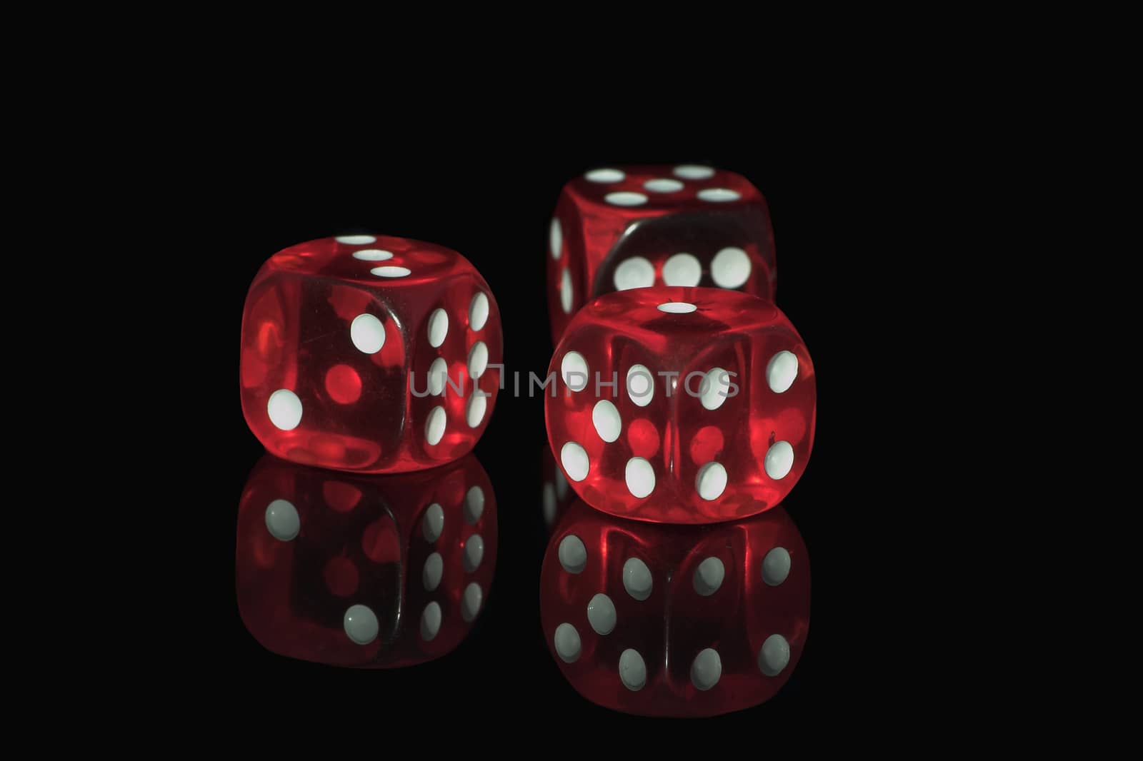 Three red casino dices on the black background