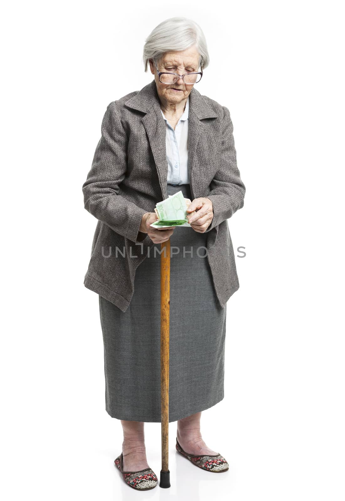 Senior woman counting money standing on white by photobac