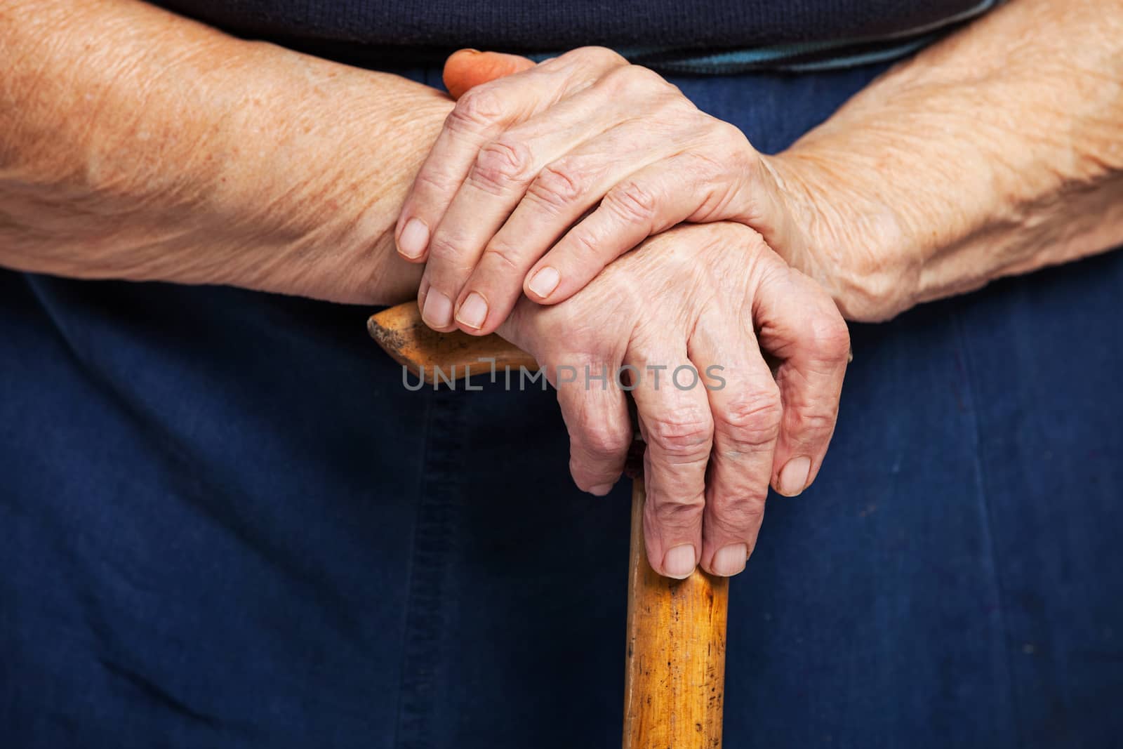 Closeup of senior woman's hands on wooden stick by photobac