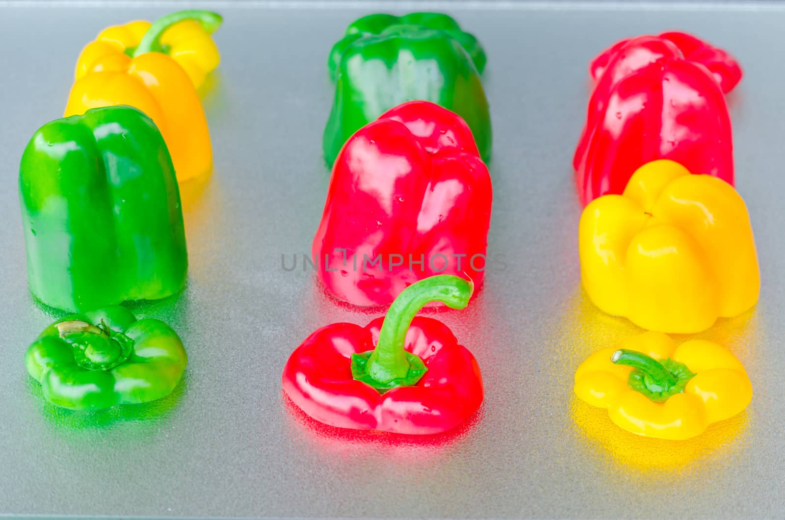 Yellow, Red, Green Bell Pepper cut on a silver platter.