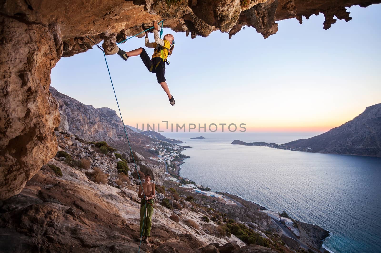 Seven-year old girl climbing a challenging route by photobac