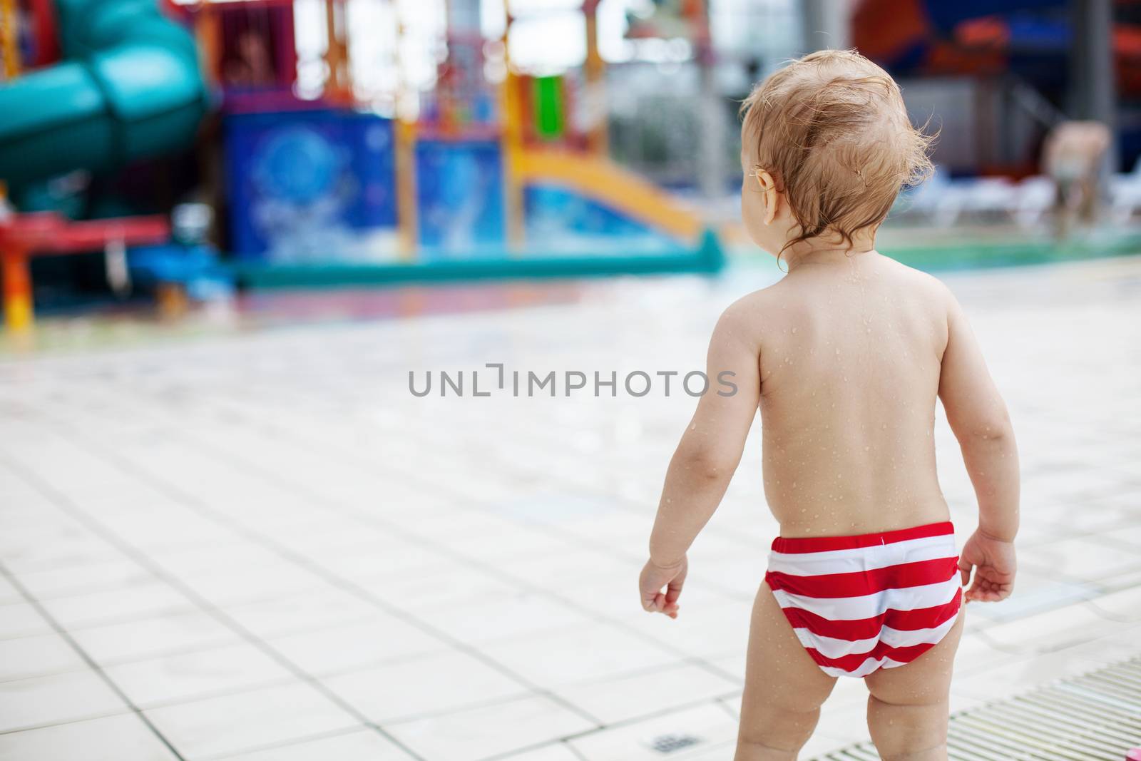 Blonde toddler boy in a waterpark indoors