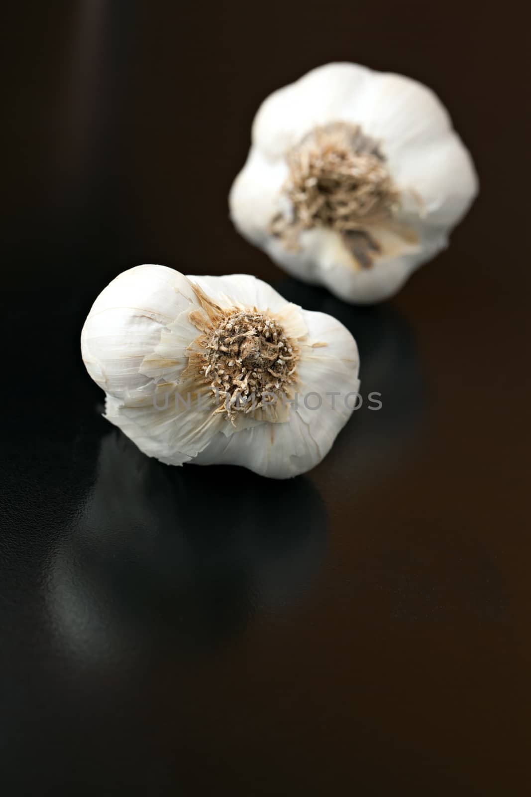Garlic bulbs isolated over a black background.  Shallow depth of field.