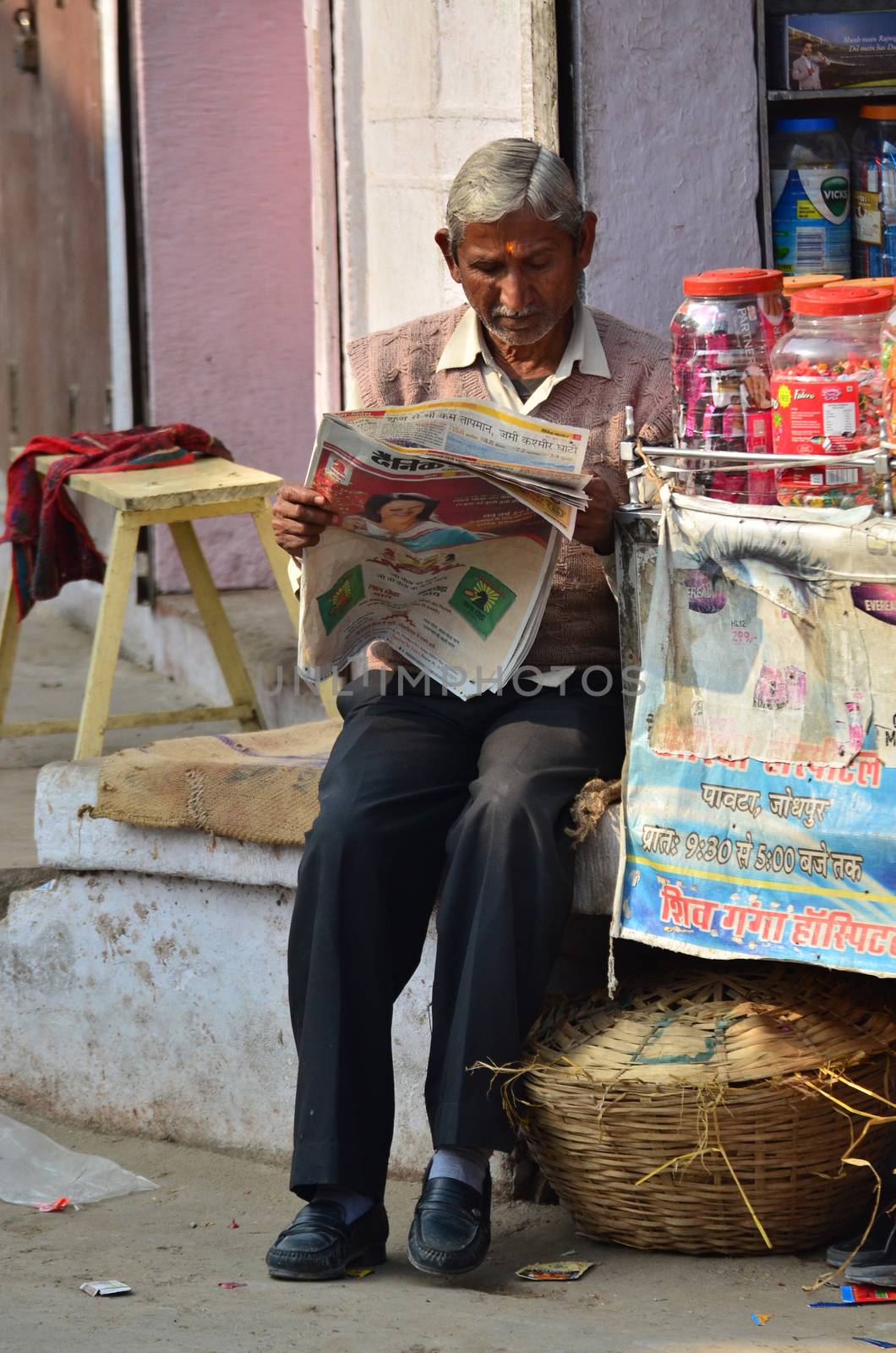 Jodhpur, India - January 1, 2015: Unidentified Indian man reading newspaper on January 1, 2015 in Jodhpur, India. Jodhpur is know as the blue city.