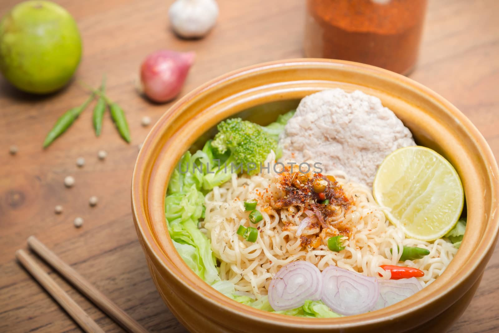 Hot and spicy noodle with pork and vegetables on the wood background