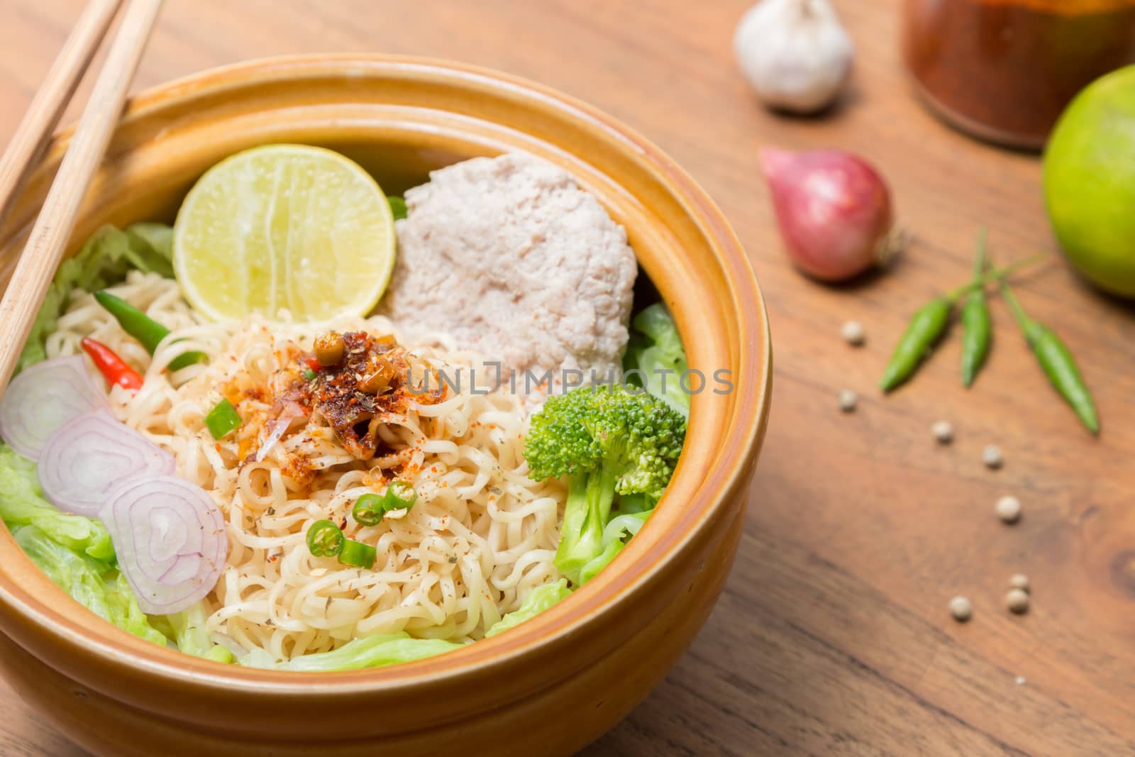 Hot and spicy noodle with pork and vegetables on the wood background