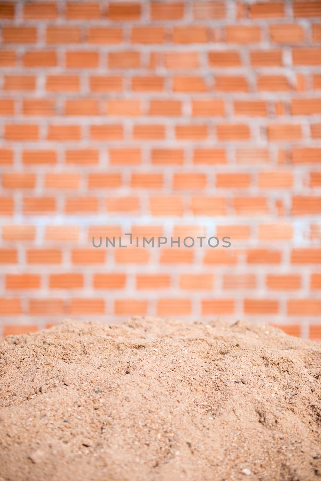 sand and brick wall in background