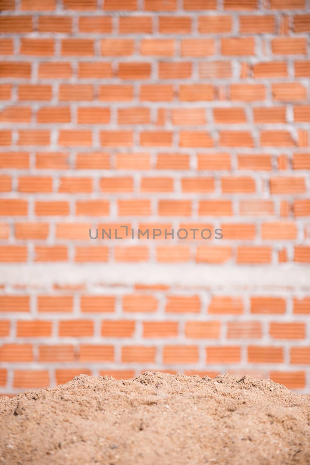 sand and brick wall in background