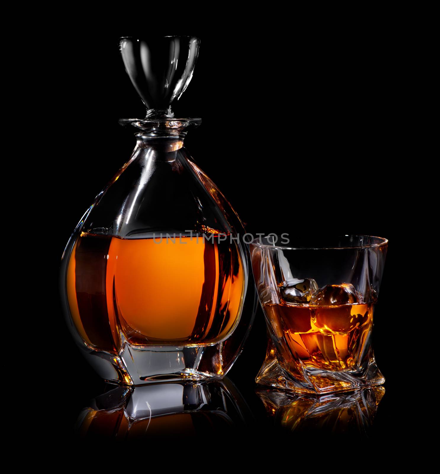 Decanter and glass of whiskaey on black background