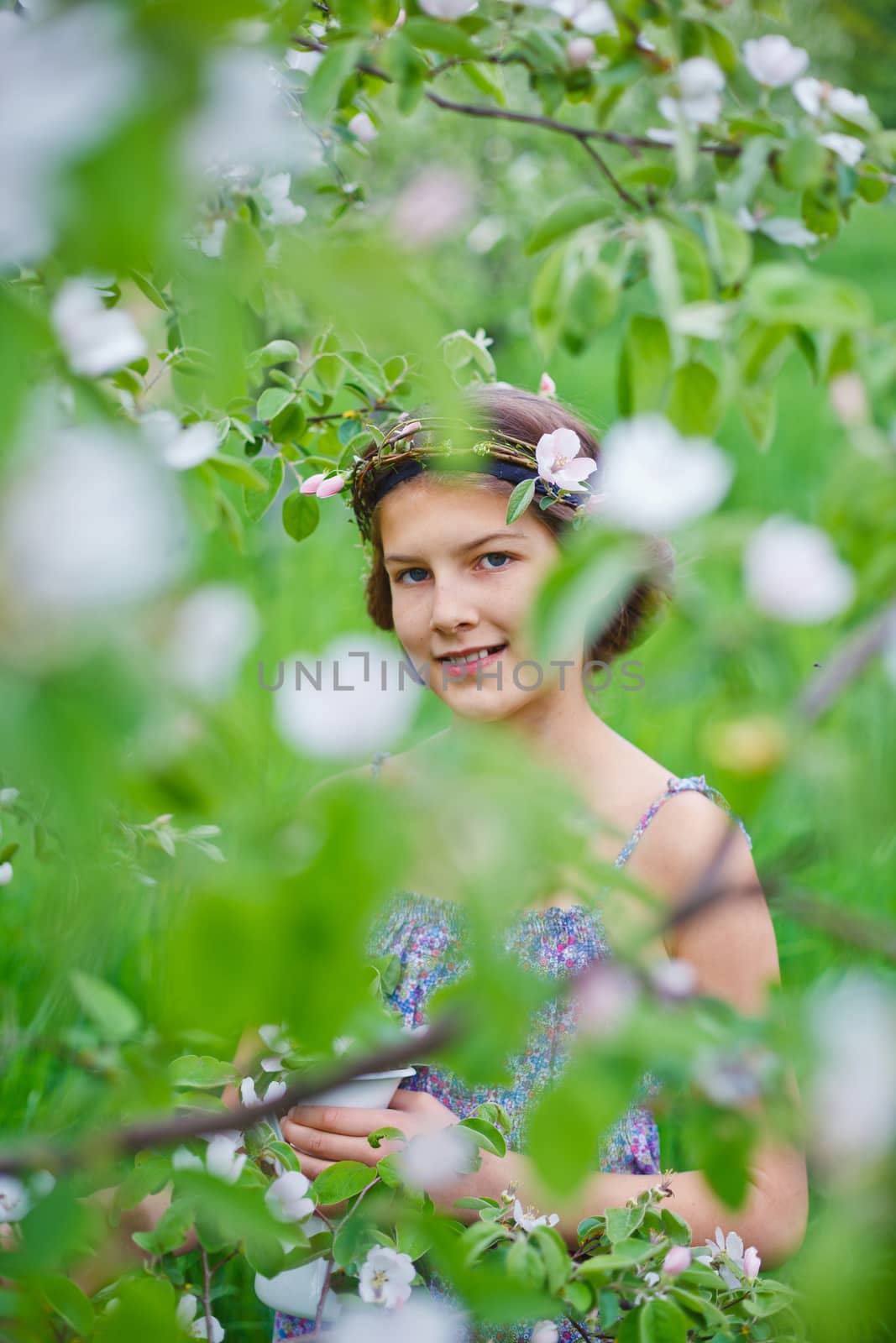 Adorable girl in blooming apple tree garden on spring day