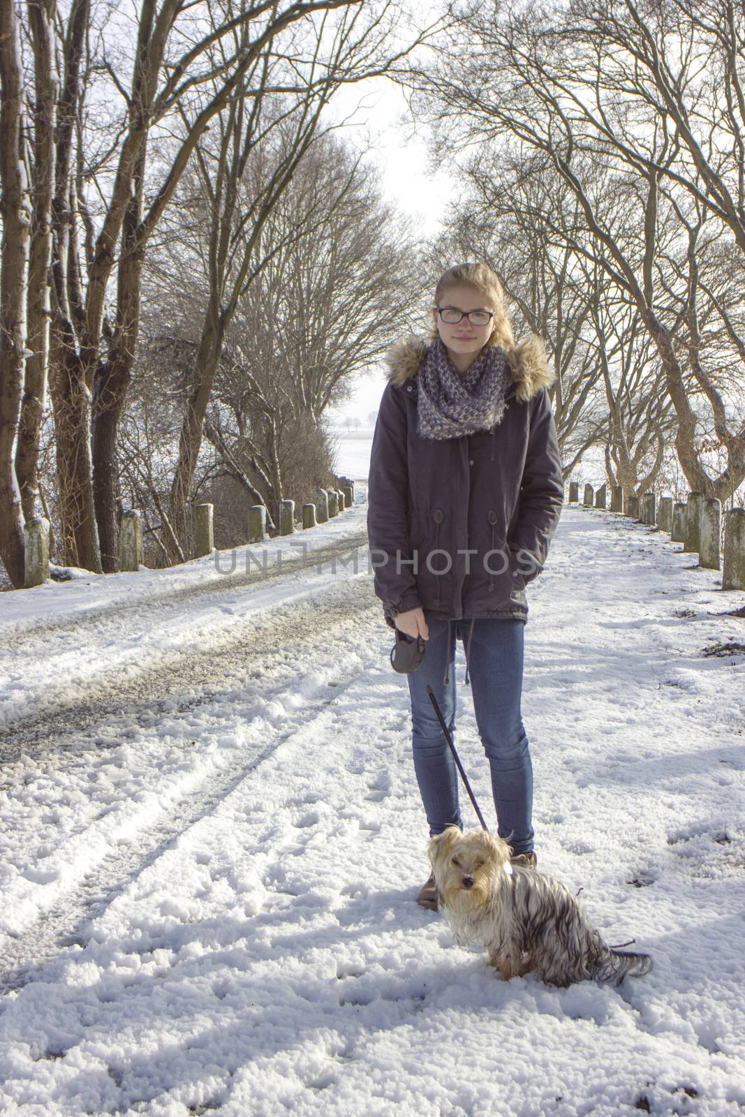 young girl with her dog on the snow in winter