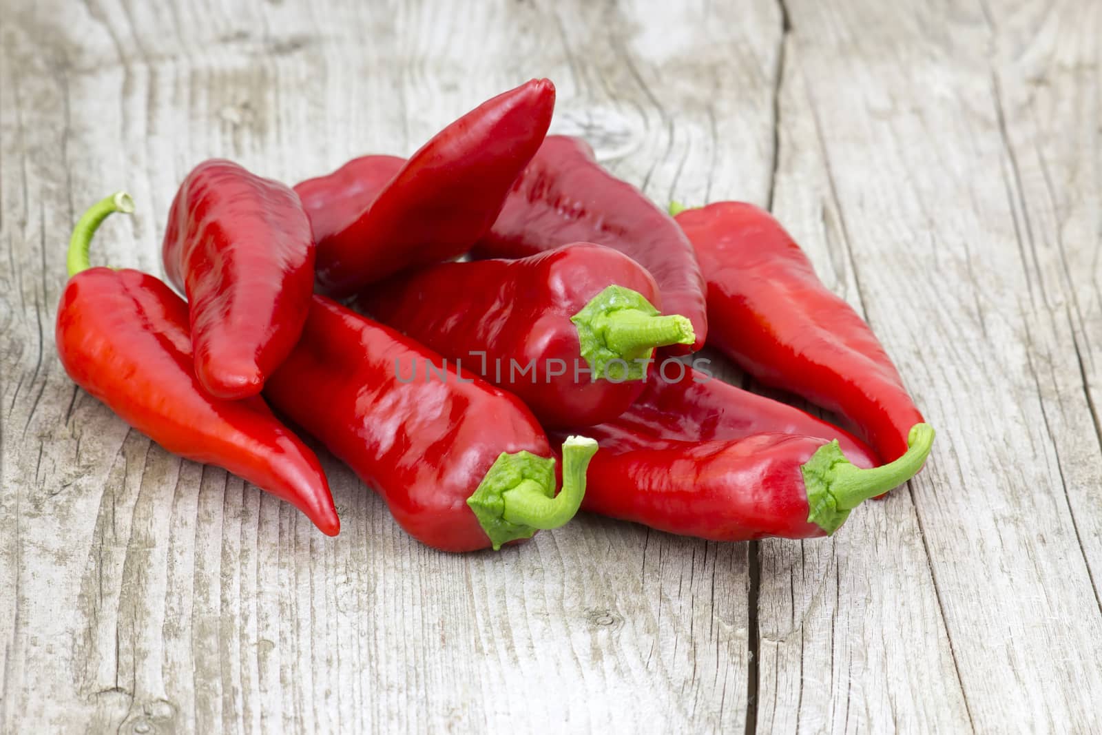 red peppers on wooden background by miradrozdowski