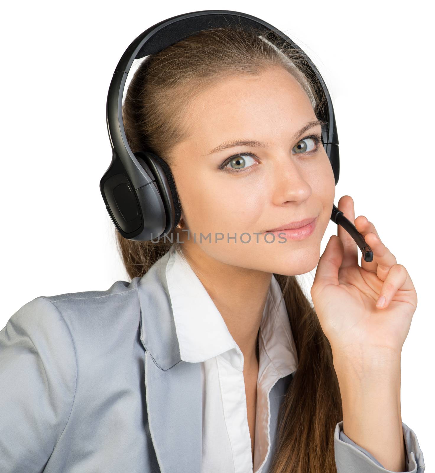 Businesswoman in headset, with her fingers on microphone boom, looking at camera. Isolated over white background