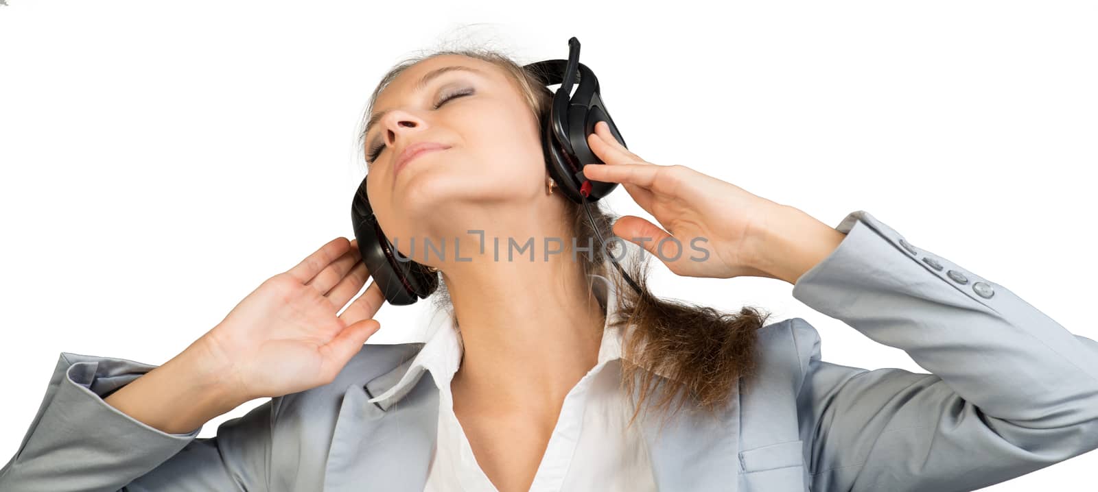 Businesswoman in headset sitting on chair with her hands on headset speakers, her head tilted sideways, eyes closed. Isolated over white background