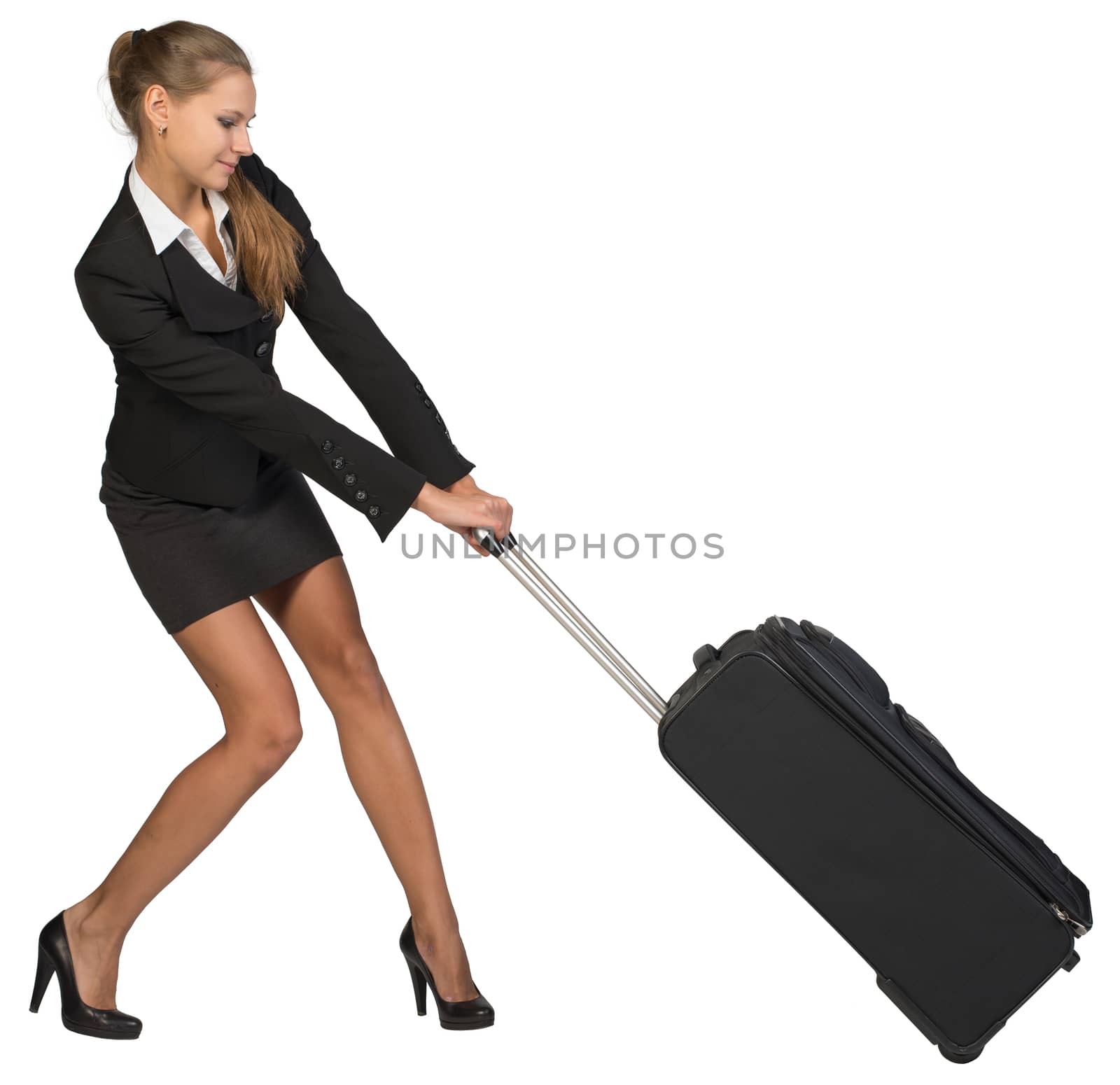 Businesswoman dragging heavy wheeled suitcase with both hands by cherezoff