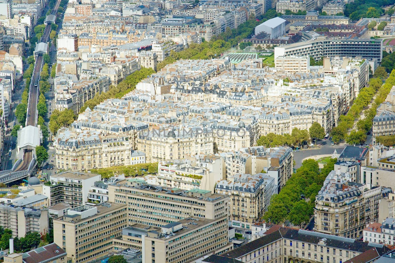 Photo shows Parisian cityscape taken on the skyscraper with various houses and monuments.