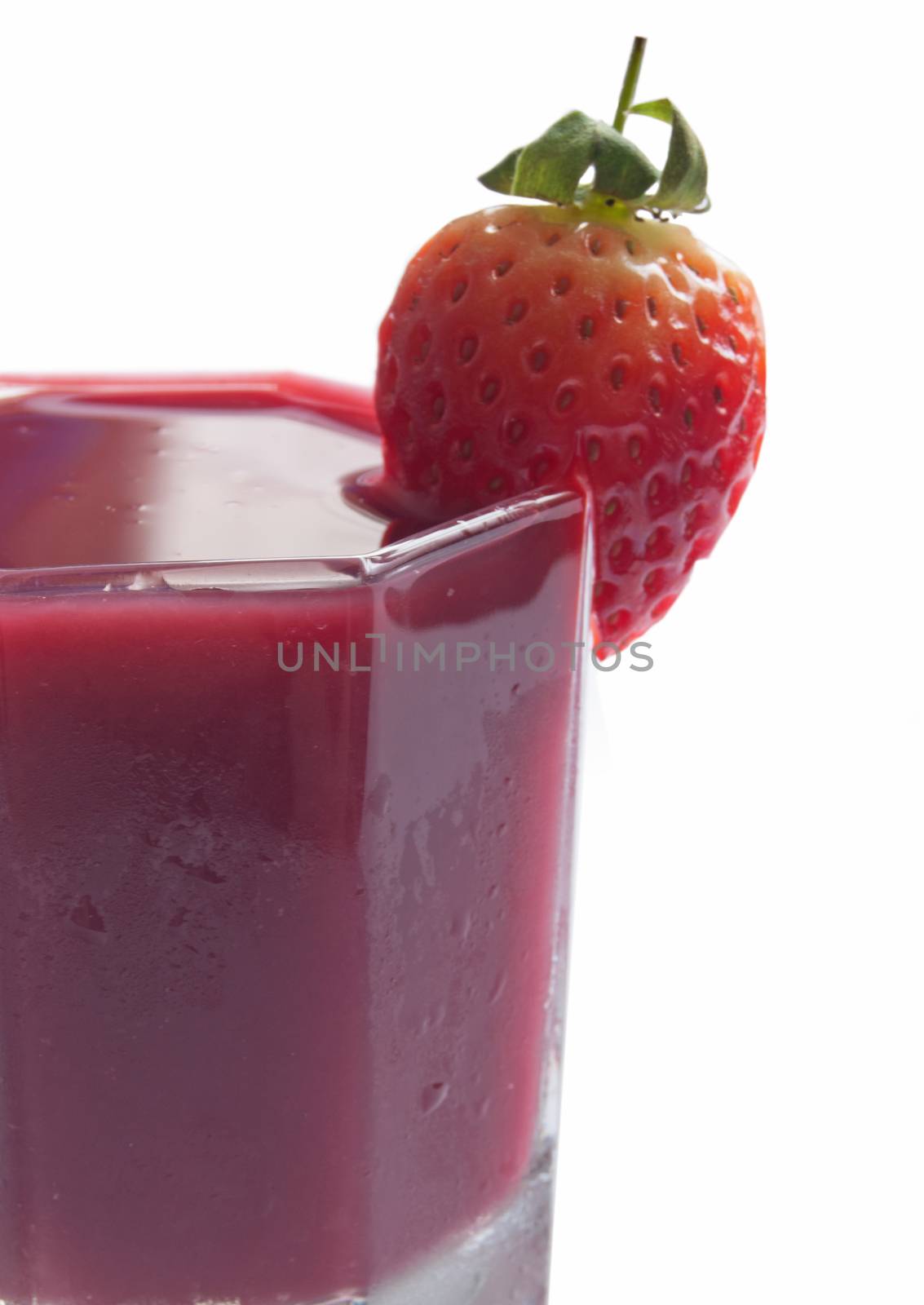 Close up of a chilled smoothie beverage with a strawberry 