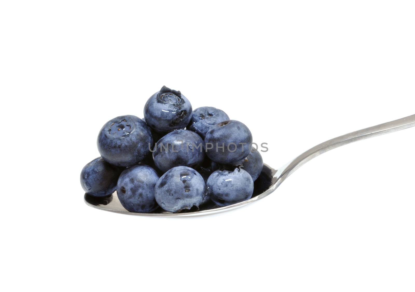 Spoonful of blueberries on a white background