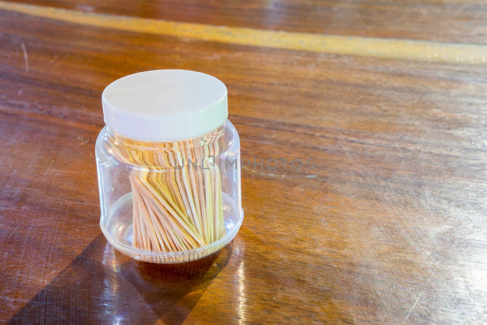 Toothpick in a bottle on a wooden table