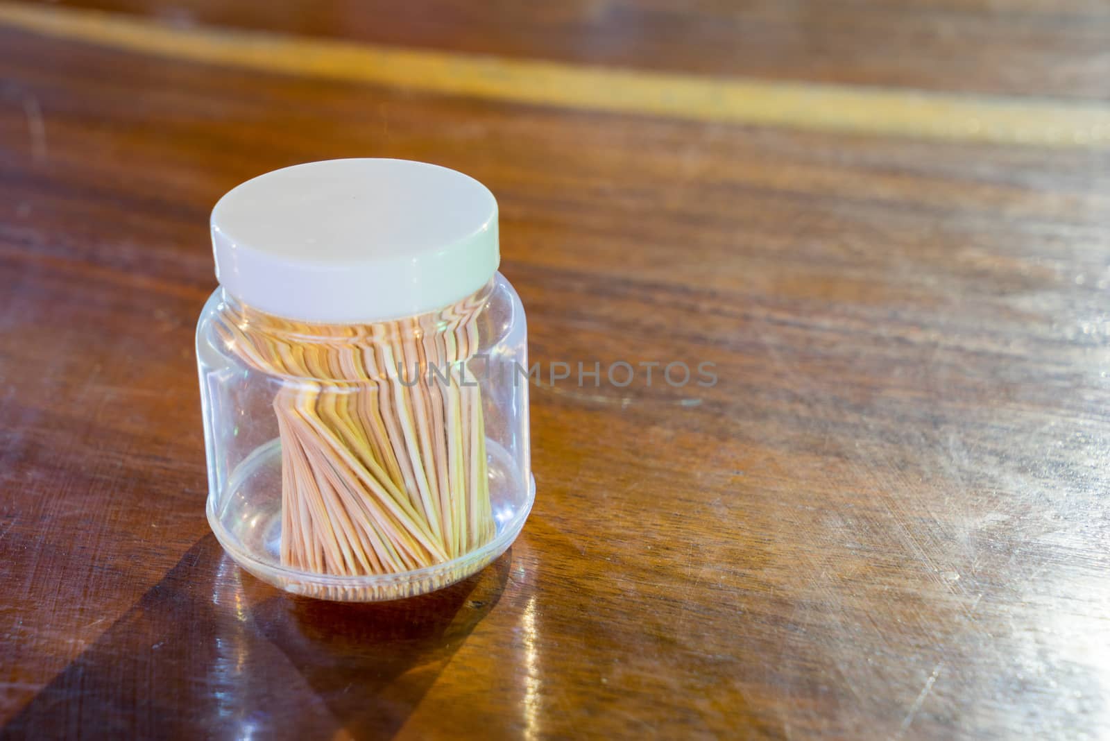 Toothpick in a bottle on a wooden table