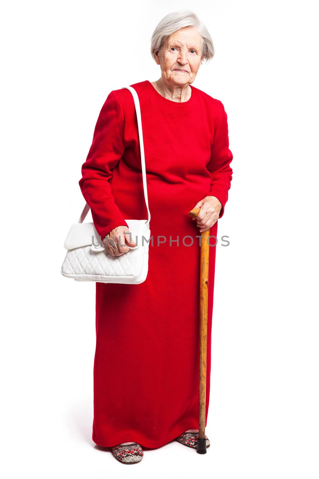 Senior woman with walking stick standing over white