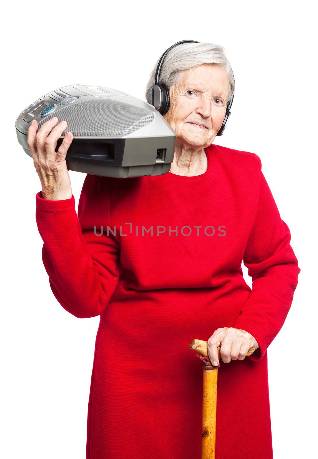 Senior woman listening to music on stereo recorder by photobac