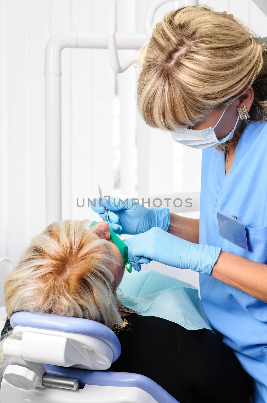 dentist at work with patient, exam, cleaning, curing, using dental water jet