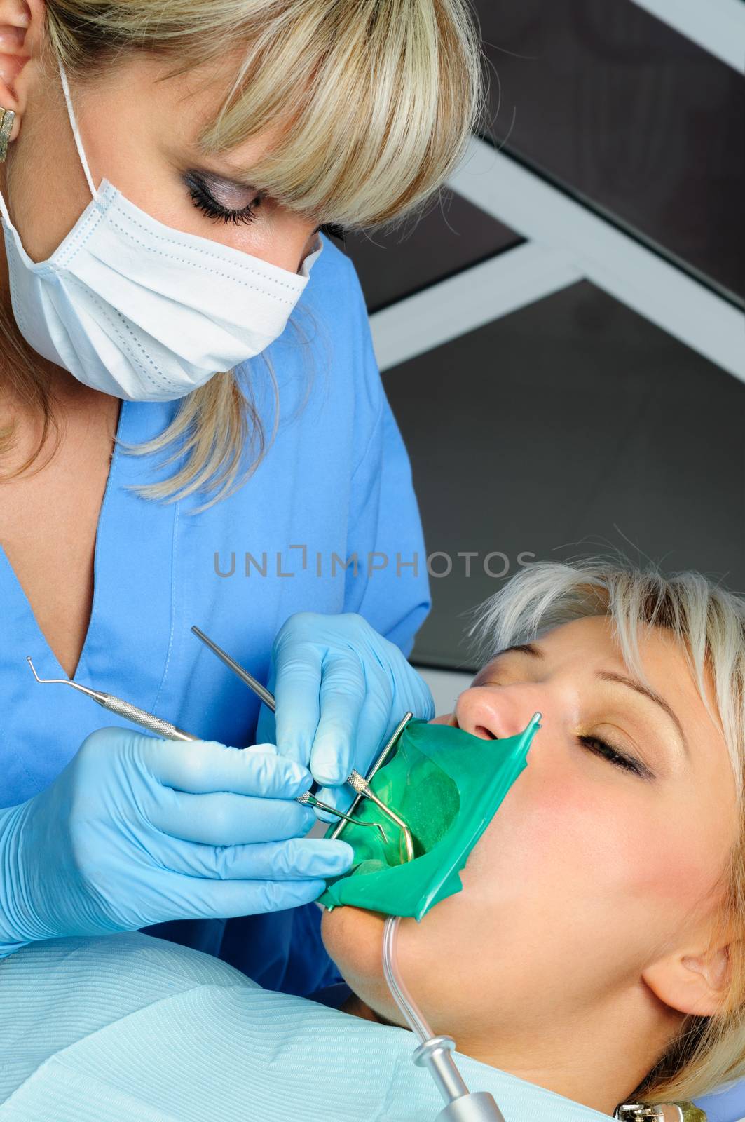 dentist with patient, cleaning and curing by starush