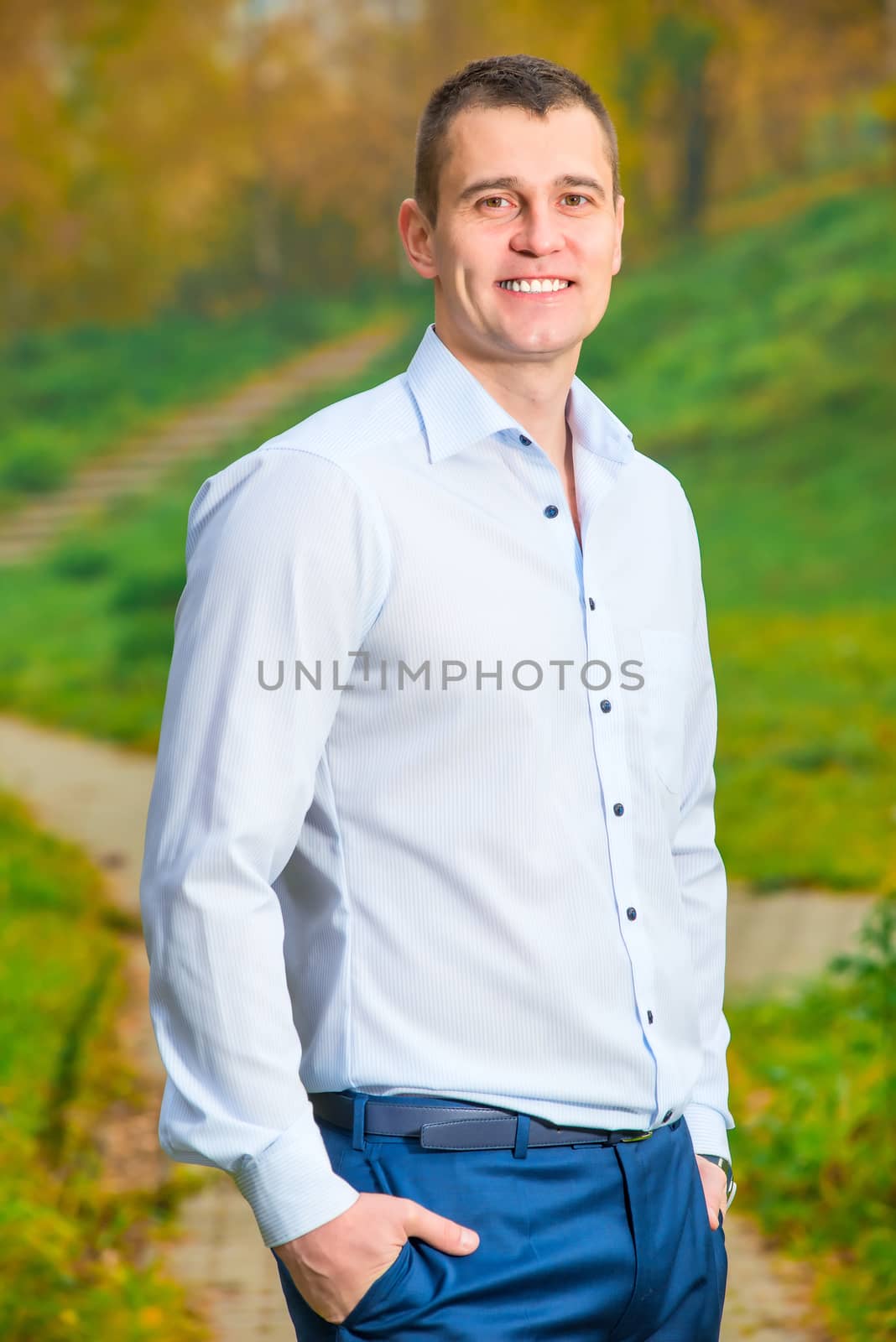 Vertical portrait of a smiling man 35 years in the park