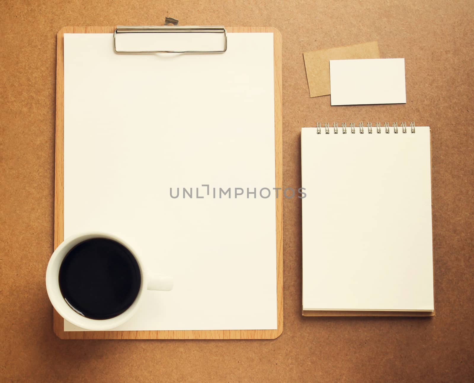 Blank white paper on clipboard and notebook with cup of coffee,  by nuchylee