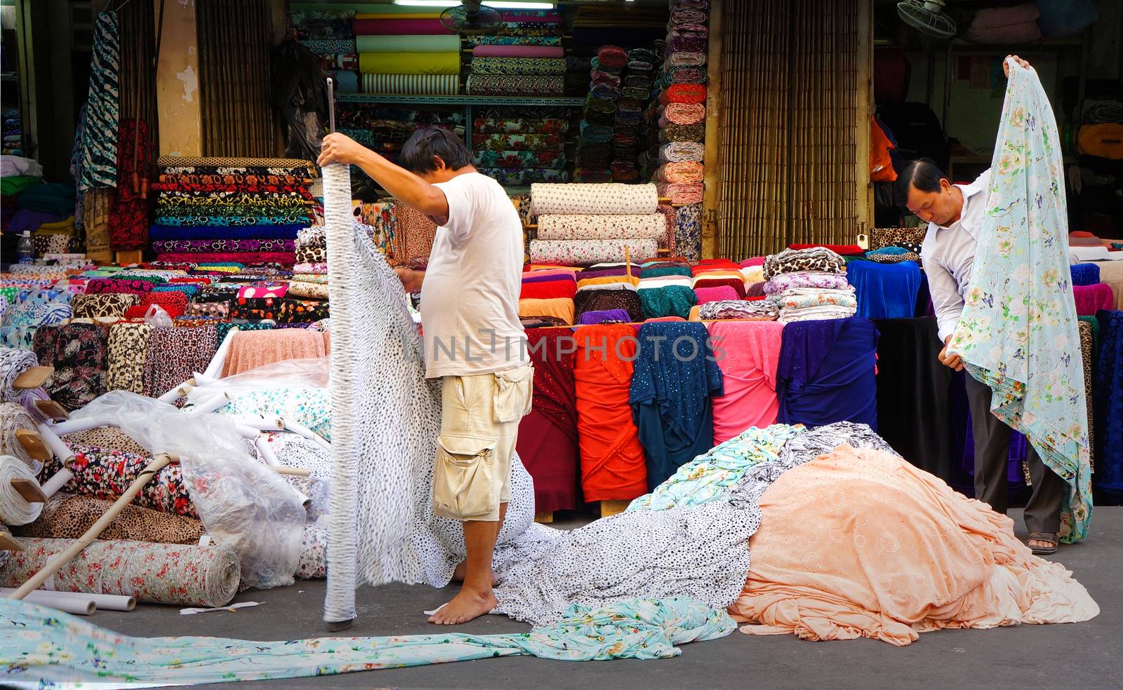 HO CHI MINH CITY, VIET NAM- DEC 28: Asia fabric market, colorful roll of cloth for clothing show at store, Vietnamese worker working at shop, garment industry develop to export, Vietnam, Dec28, 2014