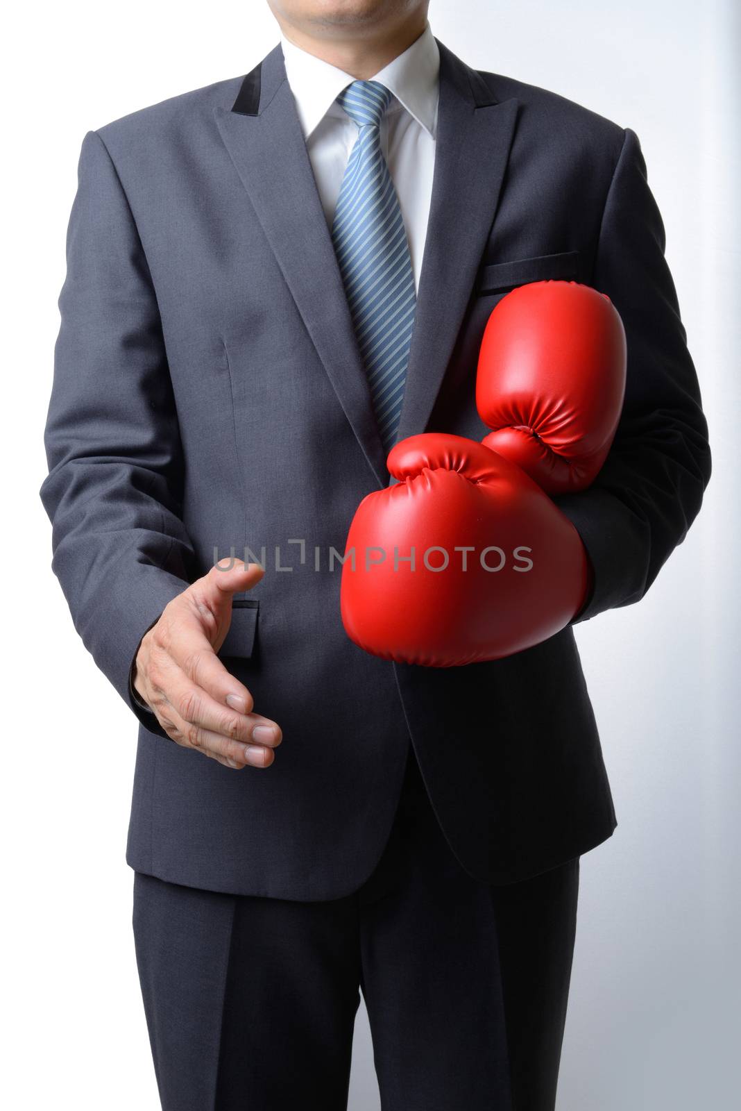 Businessman take off boxing gloves to offer a handshake on white by numskyman
