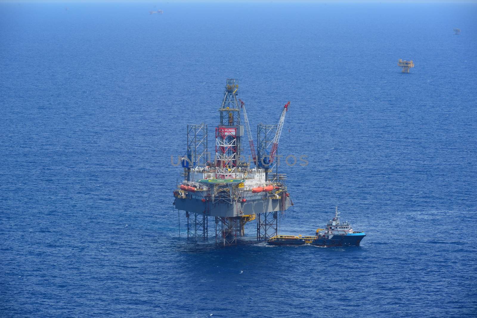 The offshore drilling oil rig and supply boat side view from aircraft.