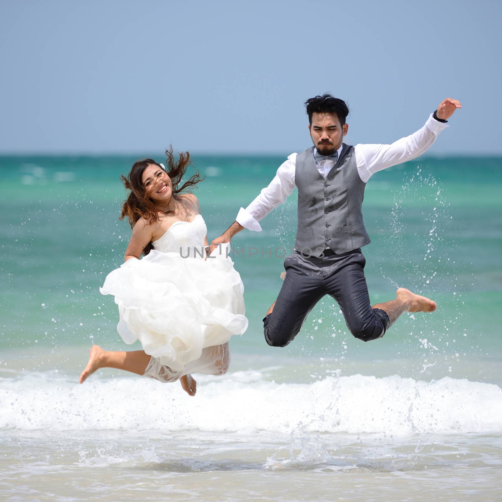 happy just married young couple celebrating and have fun at beau by numskyman