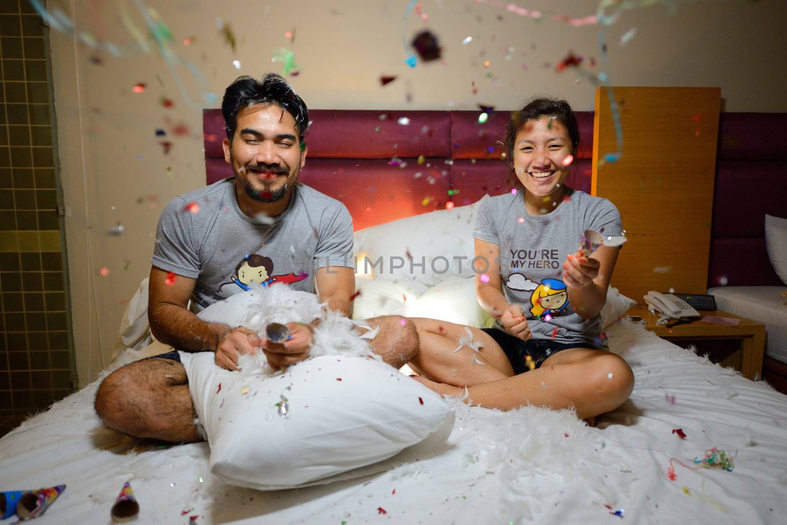 asian couple celebrating new year with fire cracker on bed